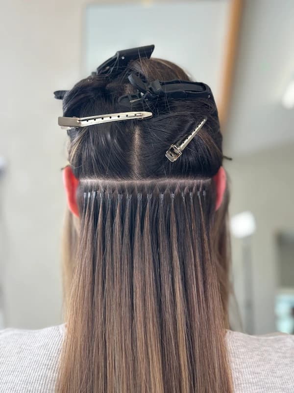 Close up of micro ring hair extensions showing invisible attachment