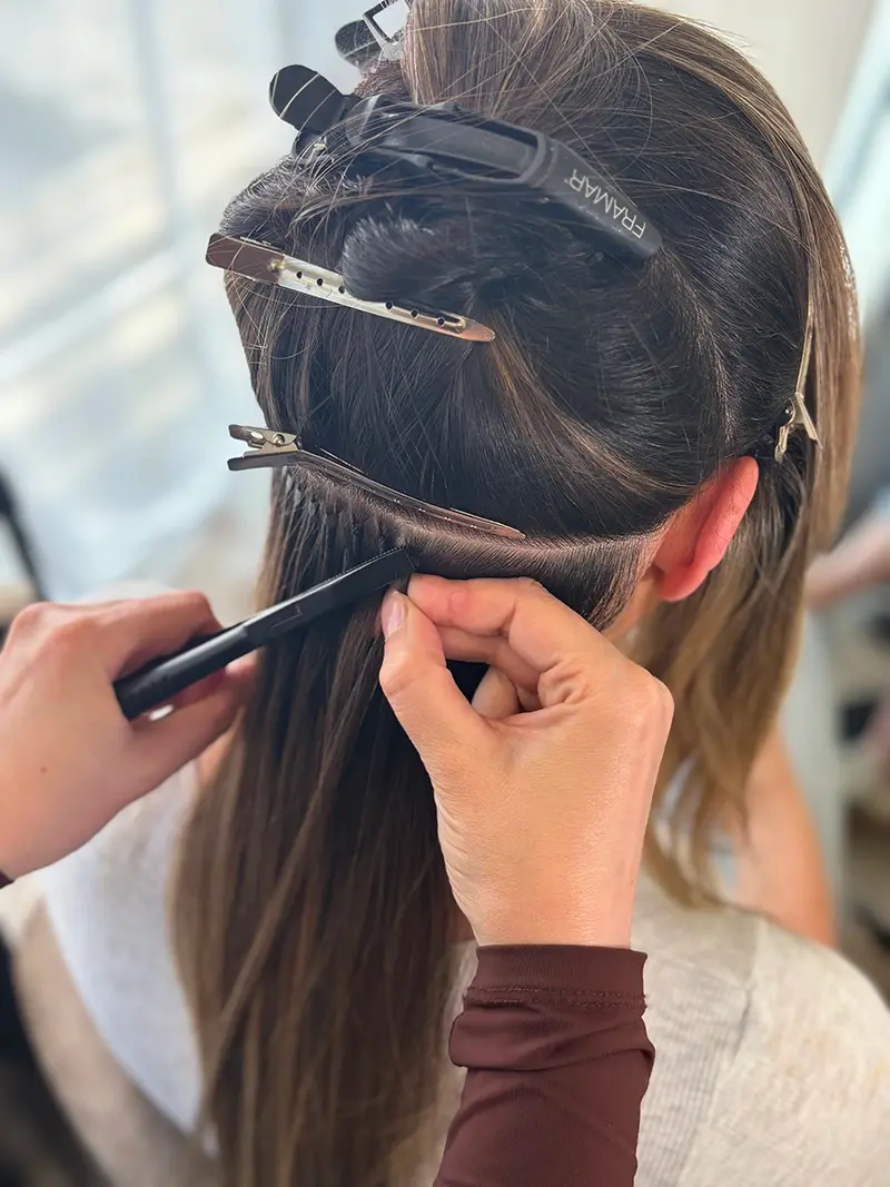During: Expert hair extension application process